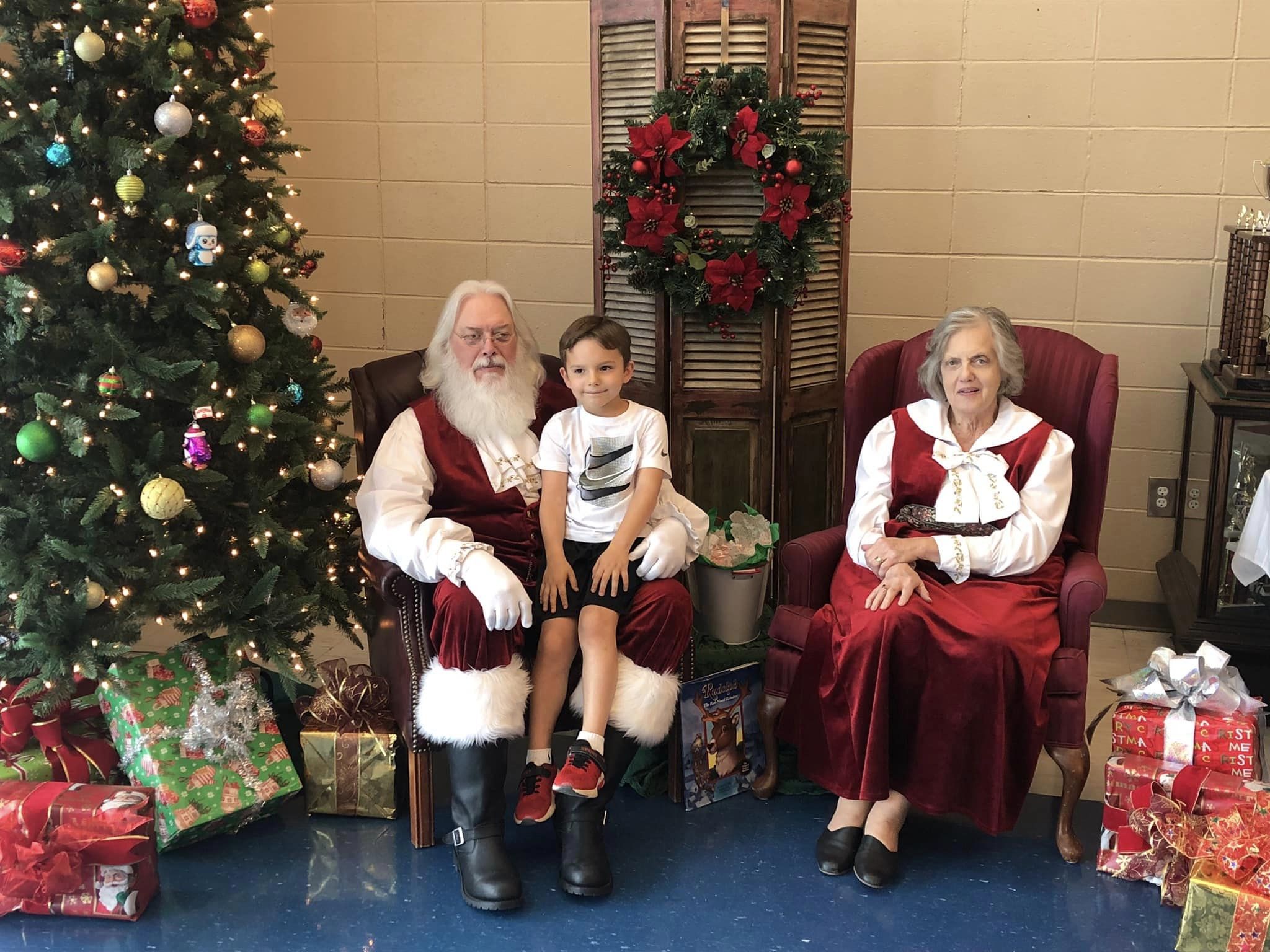 Boy sitting in Santa's lap and Mrs. Claus. 