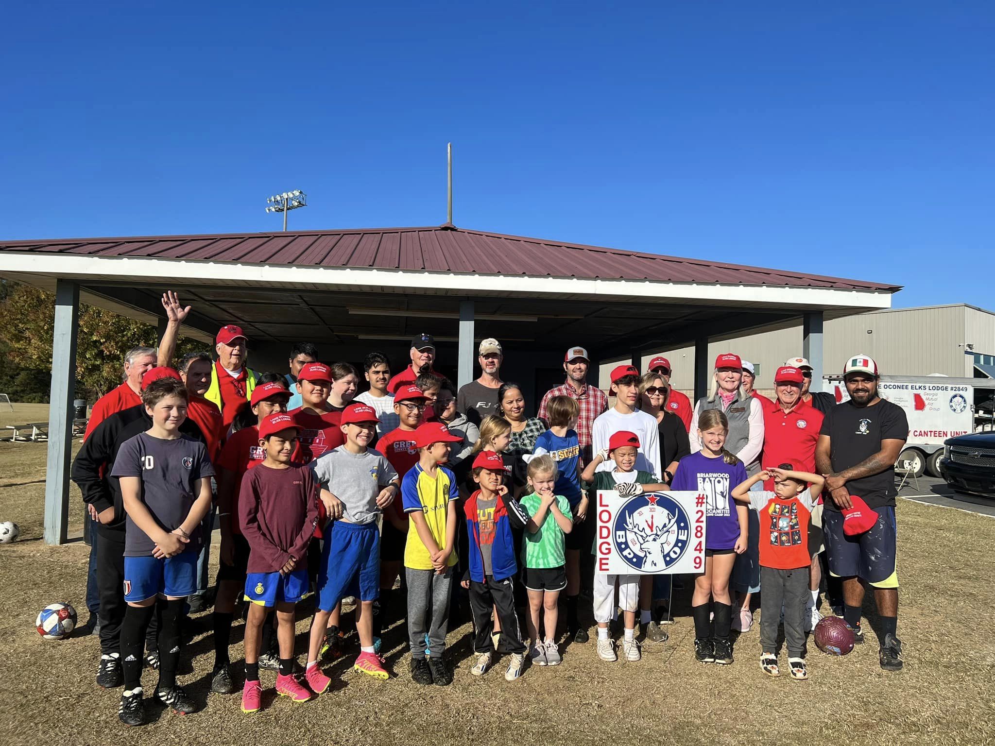Adults and children holding an Elks Lodge sign. 